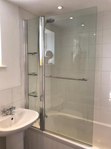 een badkamer met een douche en een wastafel bij Crosspark in Kingsbridge