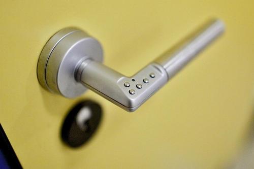 a metal door handle on a yellow door at Hostel Flensburg in Flensburg