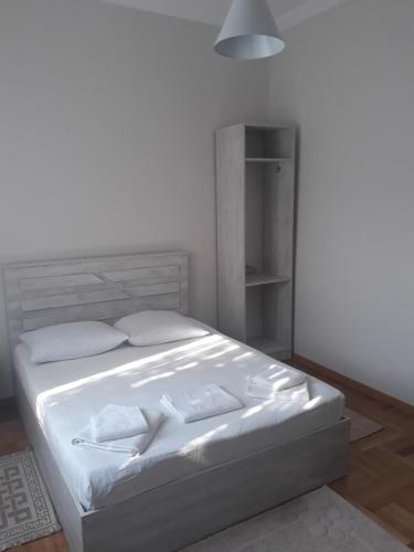 a bed with white sheets and pillows in a room at Merabi Guest House in Makhinjauri