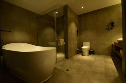 uma casa de banho com uma banheira, um chuveiro e um WC. em Kiranshree Grand em Guwahati
