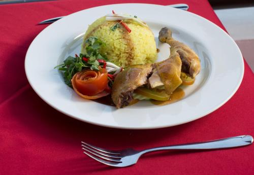 a plate of food with meat and vegetables on a red table at Queenwood Hotel in Phnom Penh