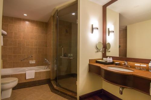 a bathroom with a sink and a shower and a toilet at Angkor Palace Suite & Villa in Siem Reap