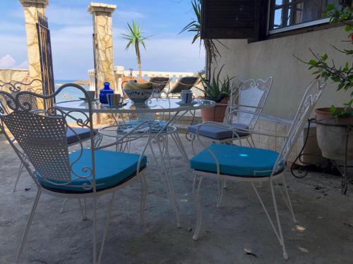 a table and chairs sitting on a patio at Villa Rena In Front of the Sea in Arkoudi
