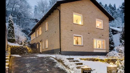 a large brick house with lights in the windows at Child friendly Villa 4BR 10 min to Gothenburg City in Partille