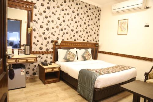 a hotel room with a bed and a mirror at Hotel Amar Inn- Lajpat Nagar Central Market in New Delhi