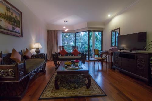 a living room with a couch and a tv at Angkor Palace Suite & Villa in Siem Reap