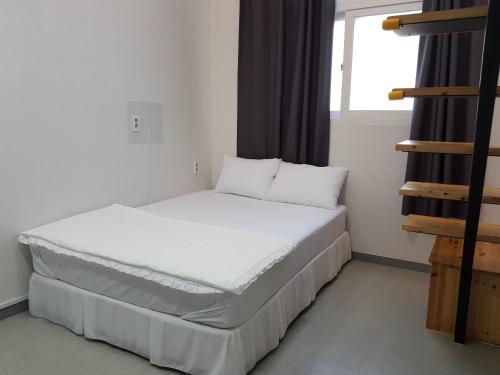a bed in a room with a window at Maison de Geoje in Geoje 