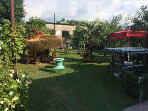 a yard with a table and chairs and a umbrella at Guest House on Kostava 23 in K'obulet'i