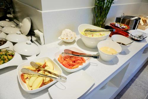 a counter with bowls and plates of food on it at Nampo Hound Hotel Premier in Busan