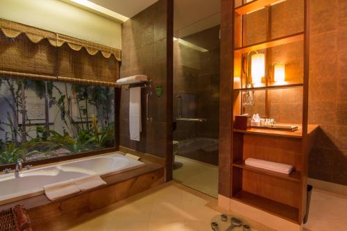 a bathroom with a bath tub and a shower at Angkor Palace Suite & Villa in Siem Reap