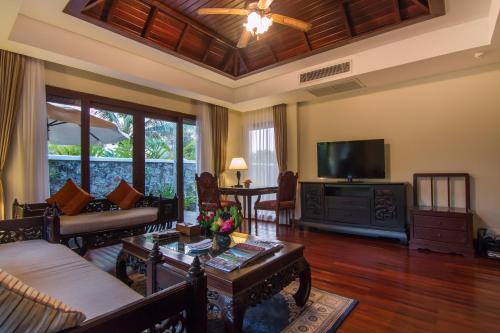 a living room filled with furniture and a flat screen tv at Angkor Palace Suite & Villa in Siem Reap