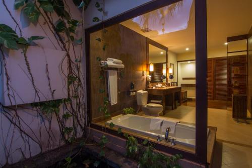 a bathroom with a tub and a toilet and a sink at Angkor Palace Suite & Villa in Siem Reap