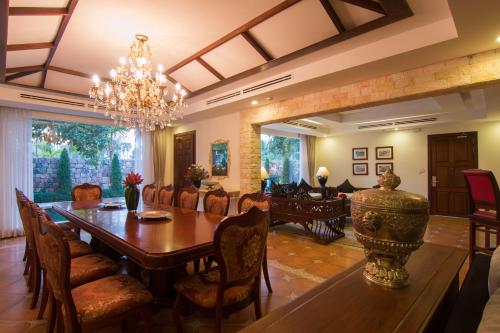 a dining room with a wooden table and chairs at Angkor Palace Suite & Villa in Siem Reap