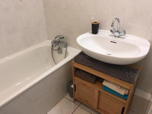 een badkamer met een wastafel, een bad en een wastafel bij Au cœur de Saint-Jorioz in Saint-Jorioz