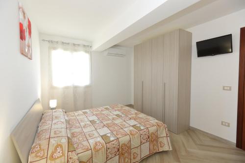 a small bedroom with a bed and a window at Villetta Giorgia in Avola