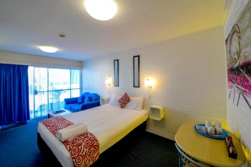 a hotel room with a bed and a table at Aspley Motor Inn in Brisbane