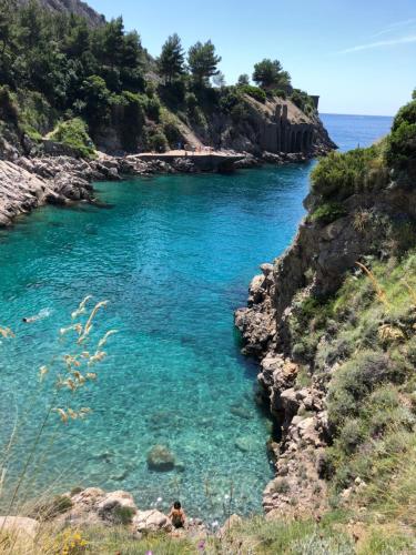 a river with blue water on a rocky shore at Petit Maison Jeranto in Nerano