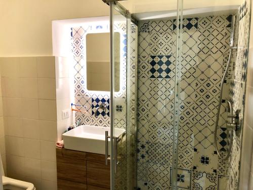 a bathroom with a shower with a sink and a mirror at Petit Maison Jeranto in Nerano