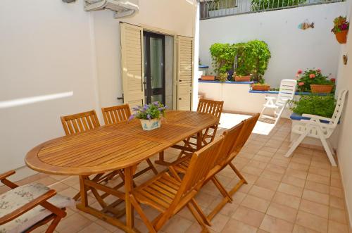 een houten tafel en stoelen op een patio bij Casa Baia Verde in Patù