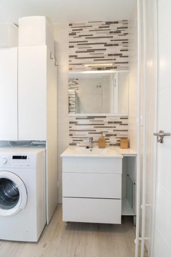a white bathroom with a sink and a washing machine at Apart CityMar 24h Terraza y vistas Ria Vigo in Vigo