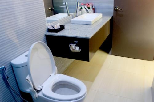 a bathroom with a white toilet and a sink at Butuan Grand Palace Hotel in Butuan