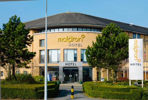 a large building with a sign on the front of it at Maldron Hotel Belfast International Airport in Aldergrove