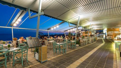 a restaurant with people sitting at tables and chairs at Samaria by the Sea in Khóra Sfakíon