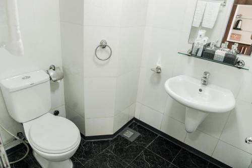 a white bathroom with a toilet and a sink at PSA Nghi Sơn Condotel in Thanh Hóa