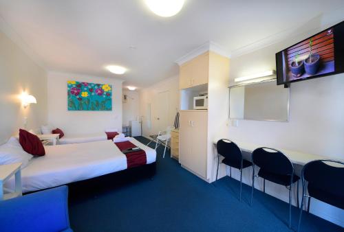 a hotel room with a bed and a table and chairs at Aspley Motor Inn in Brisbane