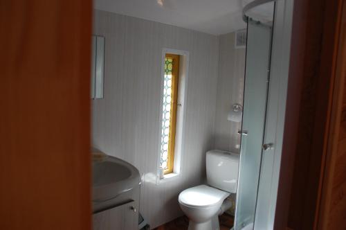 baño con aseo y lavabo y ventana en Edmundas, en Palanga