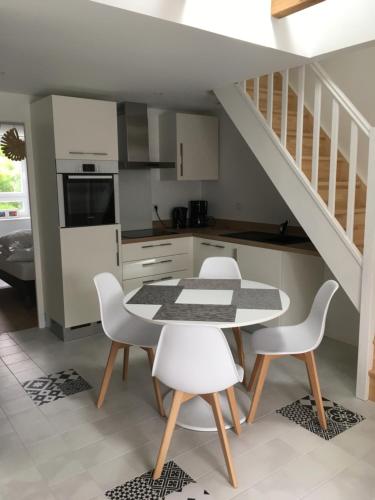 une cuisine avec une table et des chaises ainsi qu'un escalier dans l'établissement LA VILLE A LA MER N°3, à Concarneau