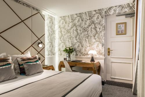 パリにあるオテル ジャルダン ル ブレアのベッドルーム1室(ベッド1台、デスク、ドア付)