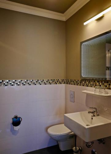 a bathroom with a white toilet and a sink at Merite Hotels Hamburg Altona GmbH in Hamburg