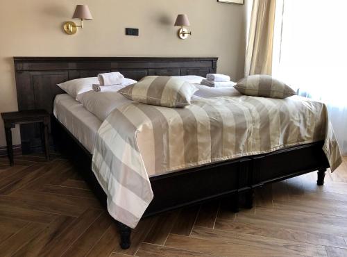 a large bed in a bedroom with a wooden floor at Merite Hotels Hamburg Altona GmbH in Hamburg