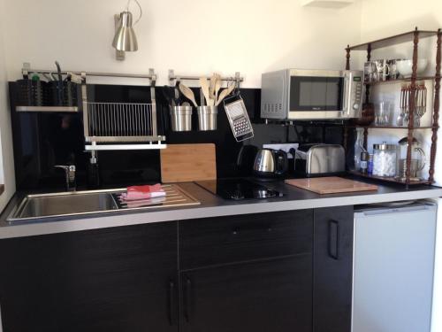 a kitchen with black cabinets and a sink at 5 rue de la Corderie in Granville