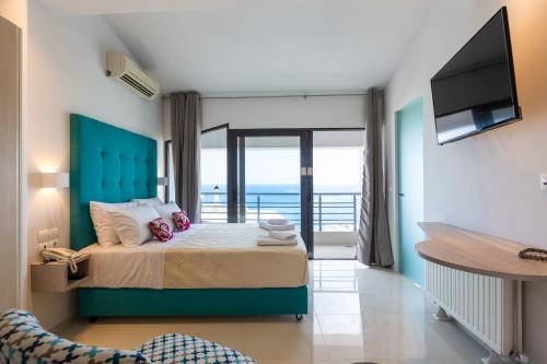a bedroom with a bed with a view of the ocean at Rethymno Hills in Rethymno Town