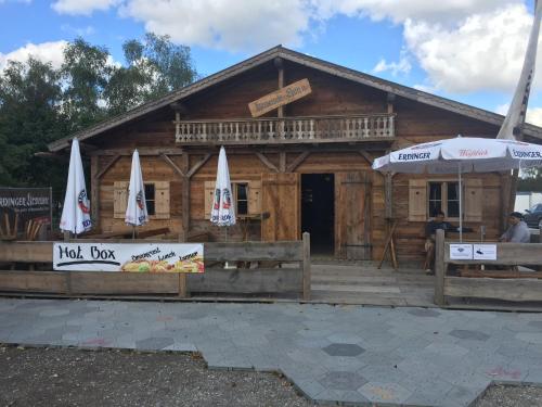 a log cabin with two umbrellas in front of it at Festanation Oktoberfest Camp #2 in Munich