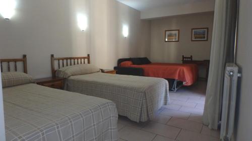 Habitación con 2 camas y manta roja. en Xalet Besolí, en Arinsal