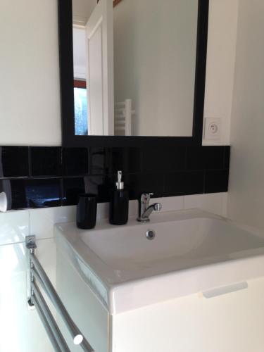 une salle de bain avec un lavabo et un miroir dans l'établissement 5 rue de la Corderie, à Granville