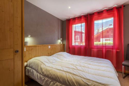 - une chambre avec des rideaux rouges, un lit et une fenêtre dans l'établissement La Ruche, à Morzine