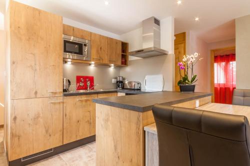 une cuisine avec des armoires en bois et un comptoir dans l'établissement La Ruche, à Morzine