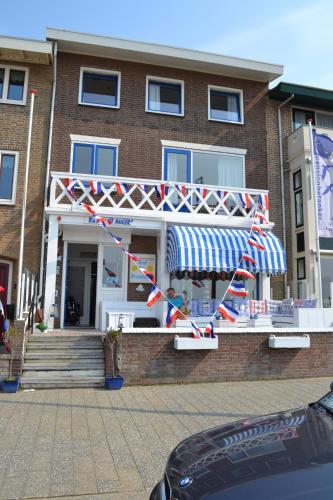 a building with a striped awning in front of it at Bed&Breakfast aan Strand in Katwijk aan Zee