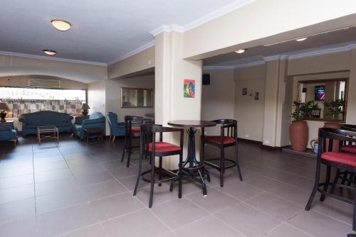 a bar with stools and tables in a room at Sunbird Capital in Lilongwe