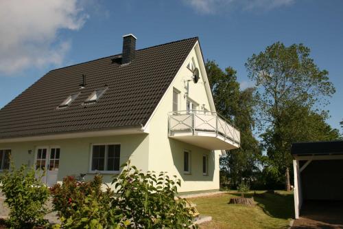 a white house with a black roof at Fewo Wiesenblick_MEYH in Ostseebad Karlshagen