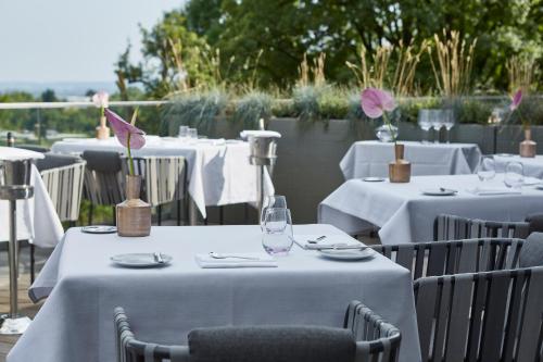 a group of tables with white tablecloths and flowers at Best Western Plus Atrium Hotel in Ulm