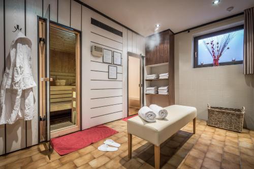 łazienka z białą ławką i kabiną prysznicową w obiekcie Hotel Scherer w mieście Valdaora