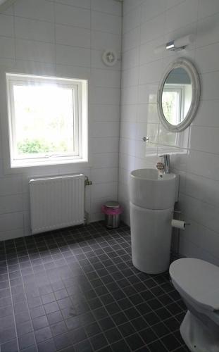 a bathroom with a tub and a toilet and a window at Nytorpsgården in Arbrå