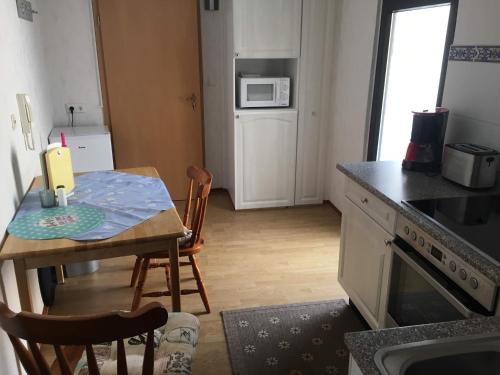a kitchen with a small table and a kitchen with a microwave at Geary Ferienwohnung in Klotten