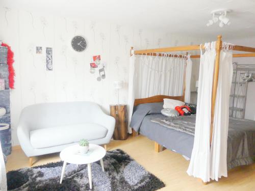 a living room with a bed and a white couch at Studio Manon in Portieux