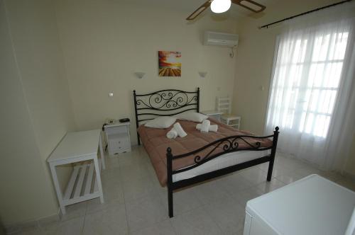 a bedroom with a bed and a table and a window at Pension Ocean View in Naxos Chora